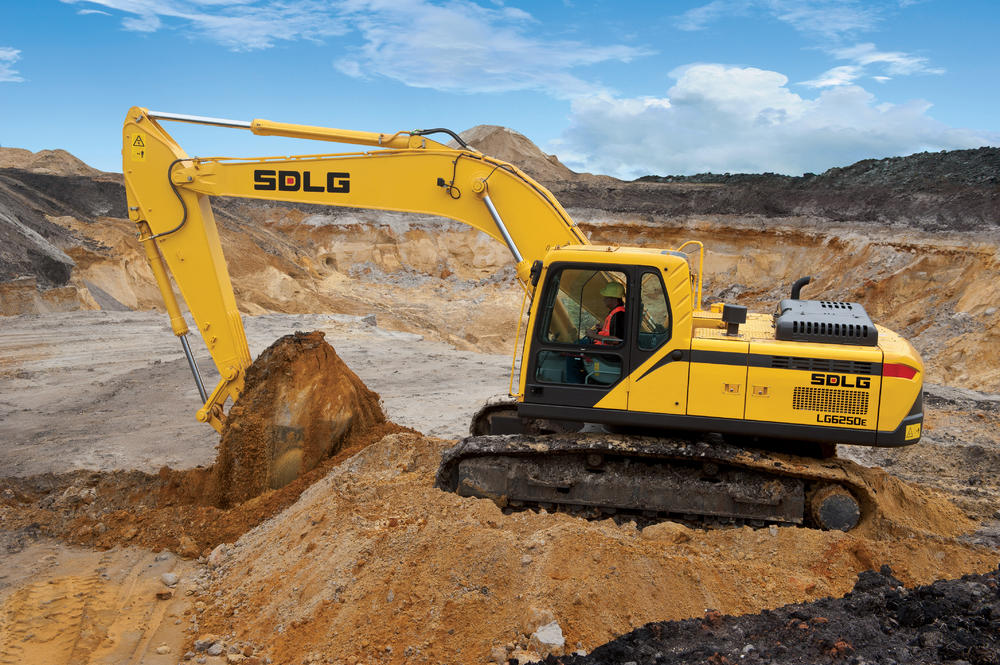 Excavadora SDLG LG6250E, excavando en un campo de tierra.