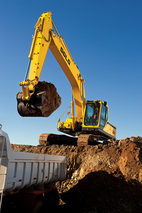 Excavadora SDLG, cargando tierra en un camión blanco.