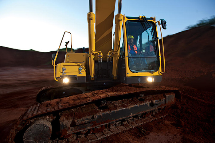 Excavadora SDLG, cargando tierra en un camión blanco.