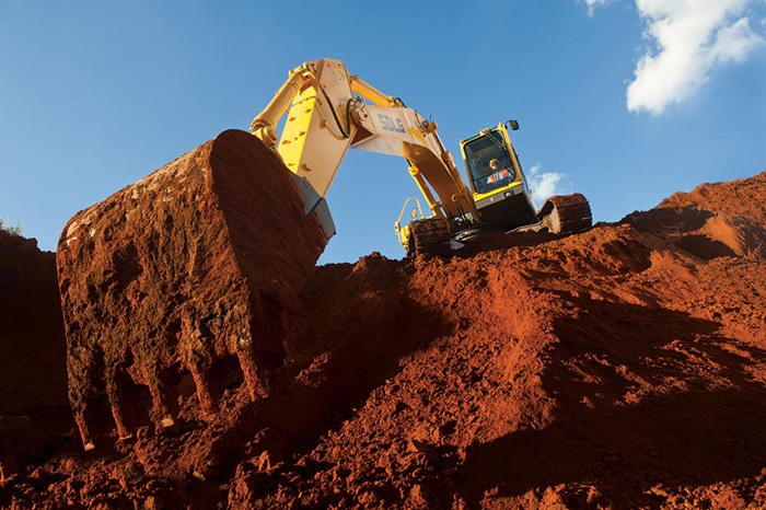 Excavadora en la cima de una colina, excavando la tierra desde la parte más baja.