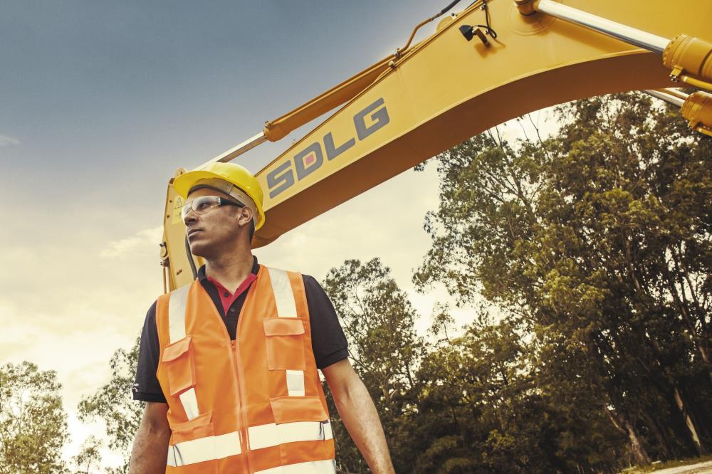 SDLG Maquinas Pesadas Imagen de un trabajador y parte de la pinza de la excavadora con el logo SDLG