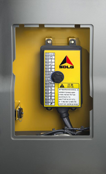 Una caja que contiene componentes eléctricos de una máquina, con un aviso de precaución.