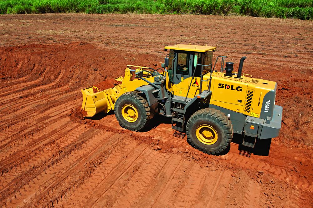 Cargadora de ruedas SDLG LG958L moviendo tierra en un campo de plantación