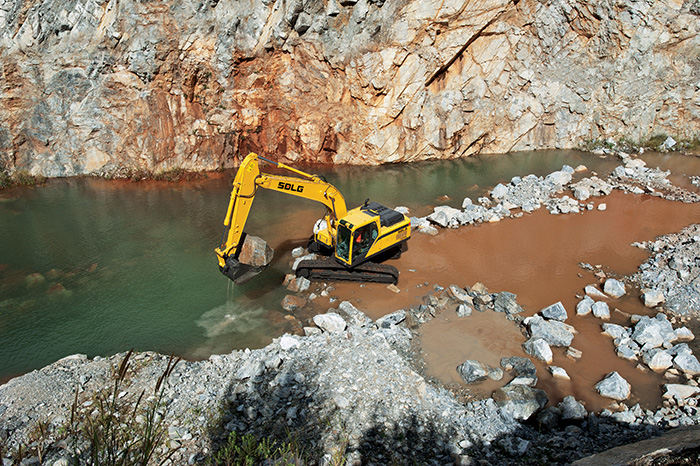 Excavadora SDLG, quitando piedras en la orilla de un río.