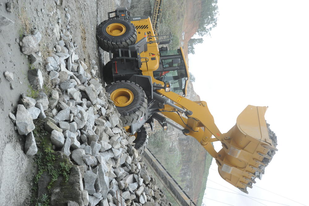 Cargadora SDLG en funcionamiento transportando piedras en el fondo de una montaña