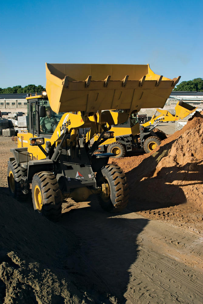 Cargador SDLG modelo LG936, vacío con el brazo de la máquina levantado, frente a un montículo de tierra.