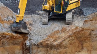Excavadora SDLG, al borde de un barranco.