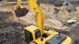 Excavadora SDLG, excavando tierra en terreno irregular.