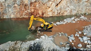 Excavadora SDLG, quitando piedras en la orilla de un río.