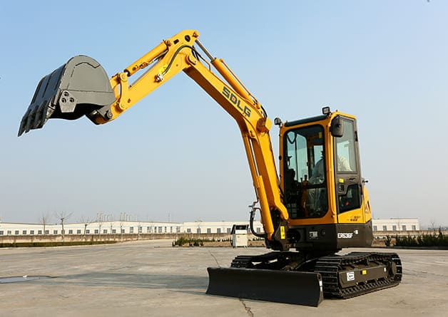 Imagem de uma máquina escavadereira compacta ER636F em um ambiente externo com a o braço mecânico virado para cima.