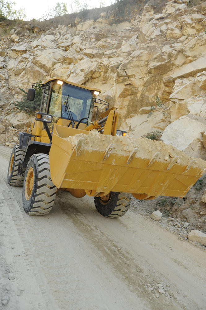 Cargadora de ruedas SDLG en funcionamiento transportando tierra y piedras