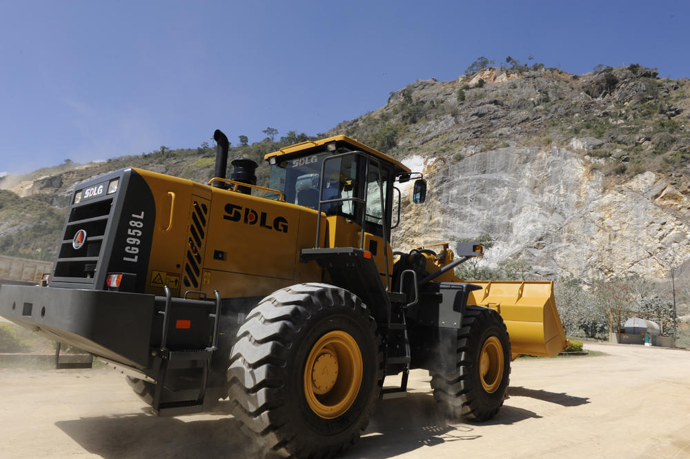 Cargadora de ruedas SDLG LG958L frente a un muro de piedra