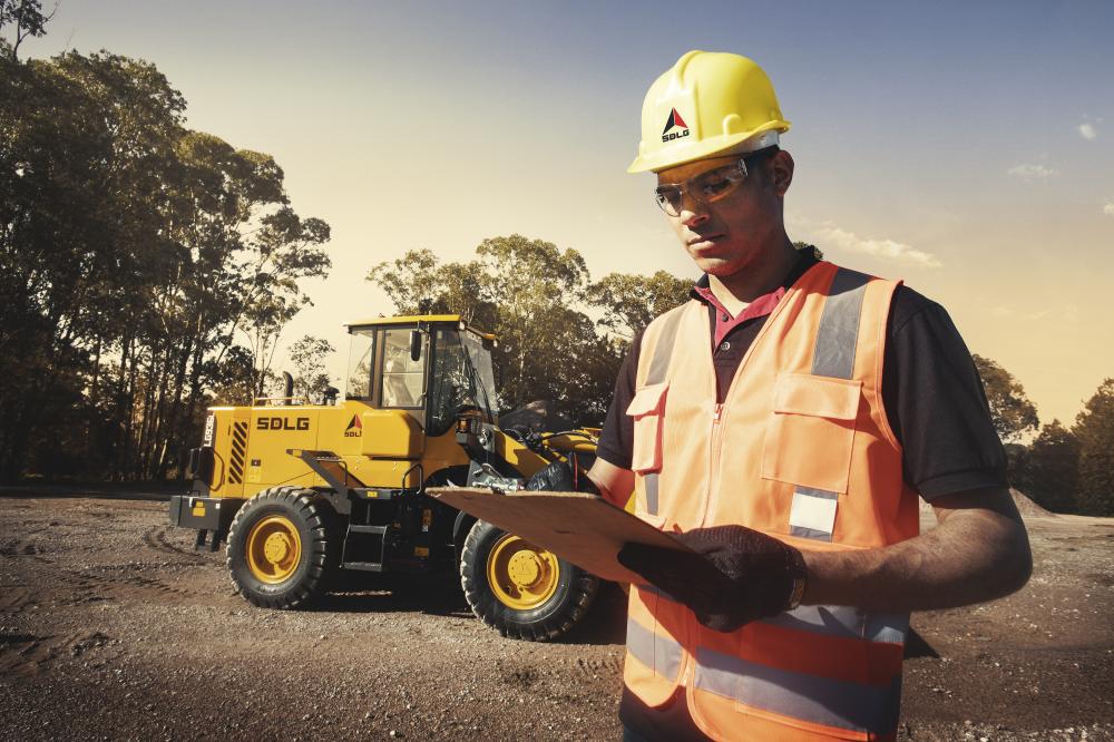 Trabajador, frente a una máquina pesada SDLG.